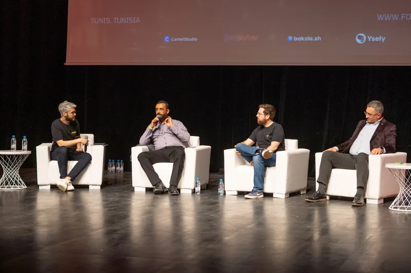 Aziz Ouertani hosting a roundtable about AI and software delivery on stage